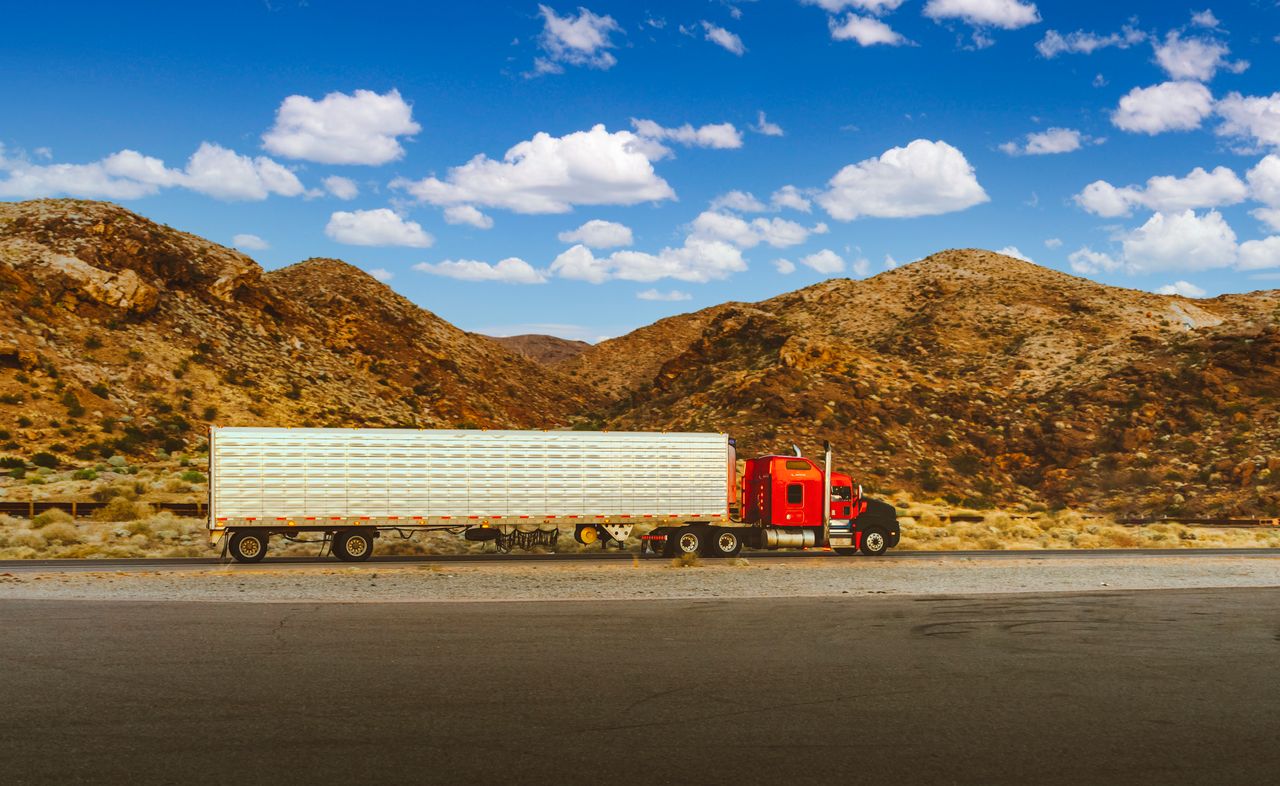 Mastering the First Impression: Your intriguing post title goes here A vibrant red semi-truck travels through a desert highway with mountain views in Nevada.